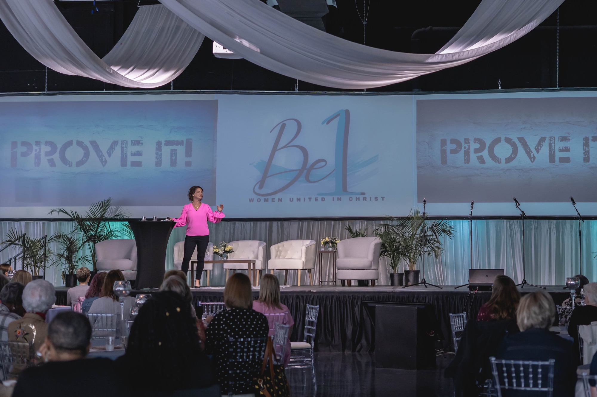 Amanda Box speaking on stage at a past Be1 Experience