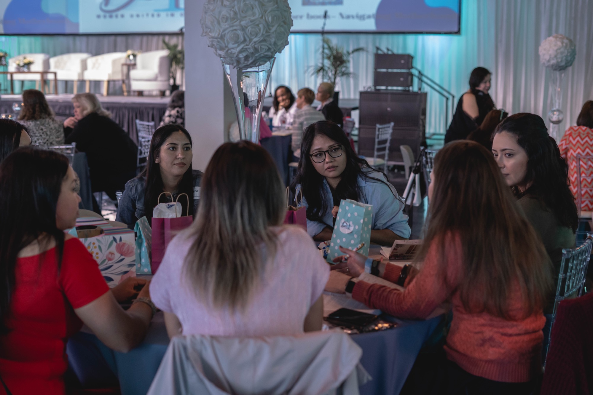 Attendees connecting at tables during a past Be1 Experience