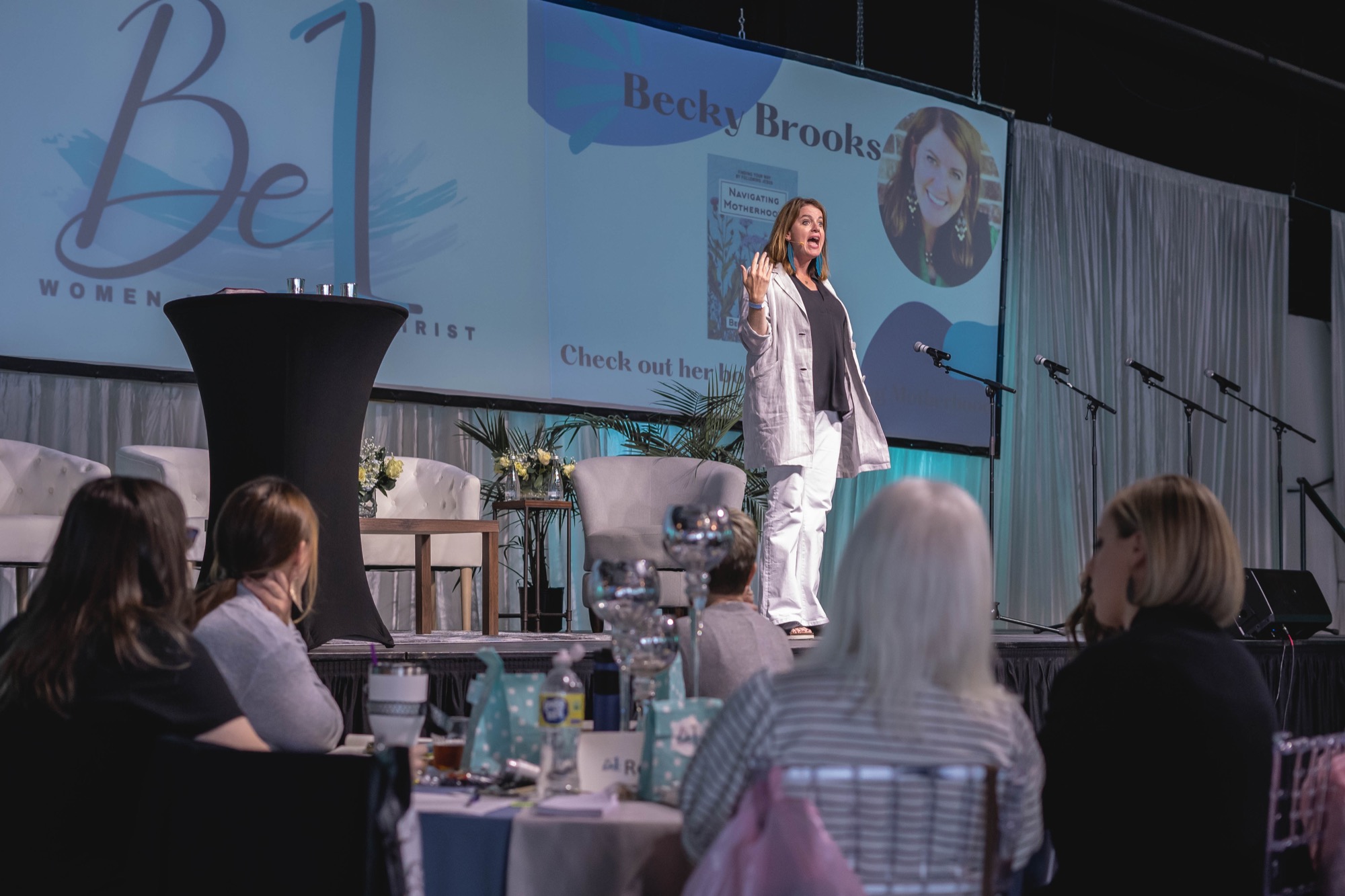 Becky Brooks speaking on stage at a past Be1 Experience