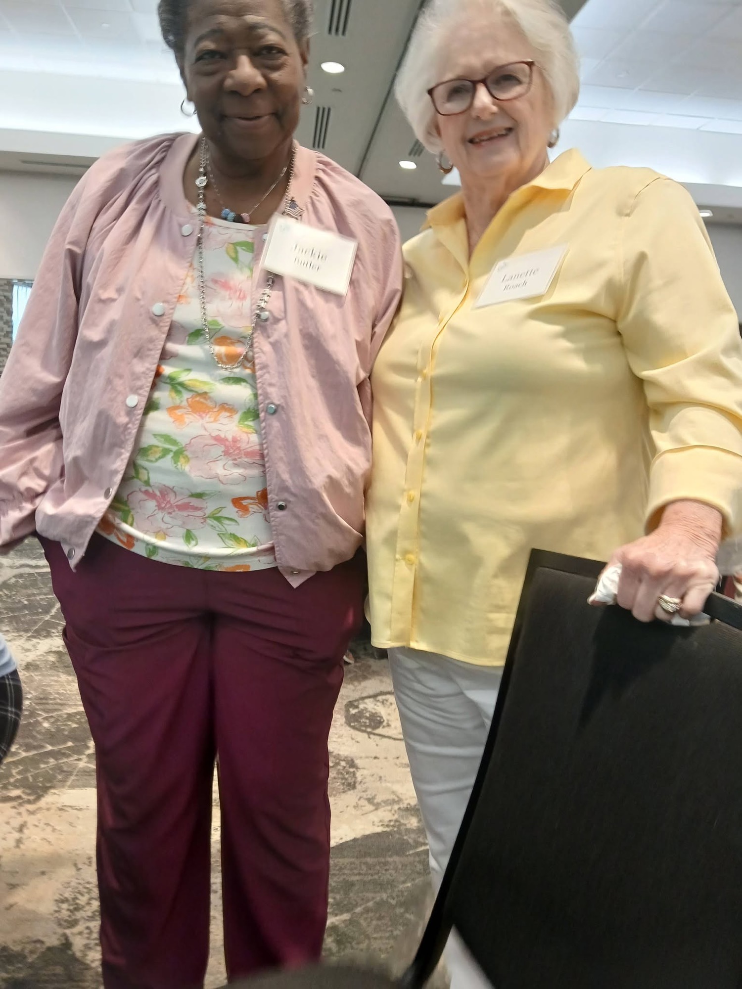 Two women smiling together at a past Be1 Experience