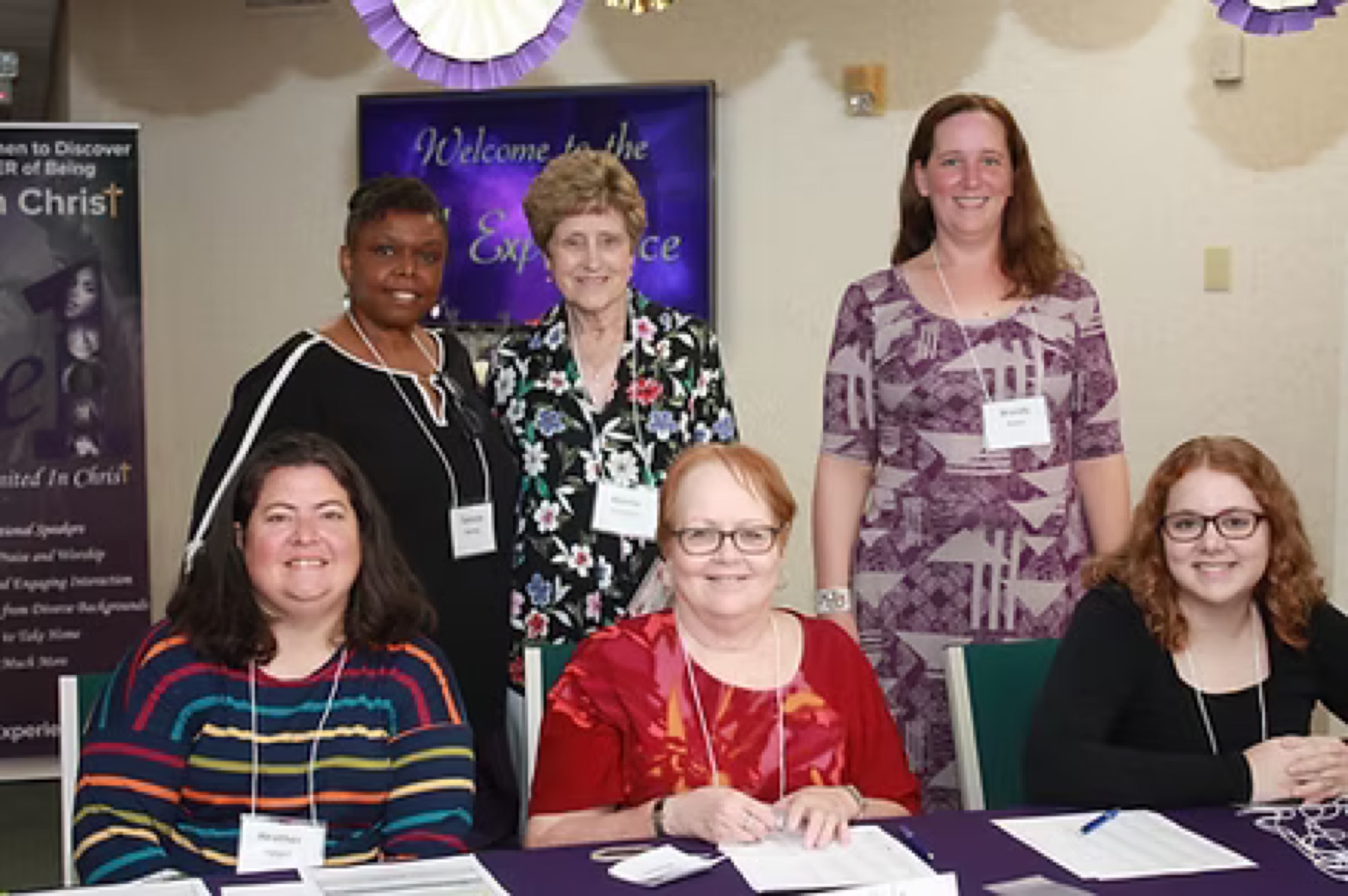Group of women celebrating together at a past Be1 Experience welcome table