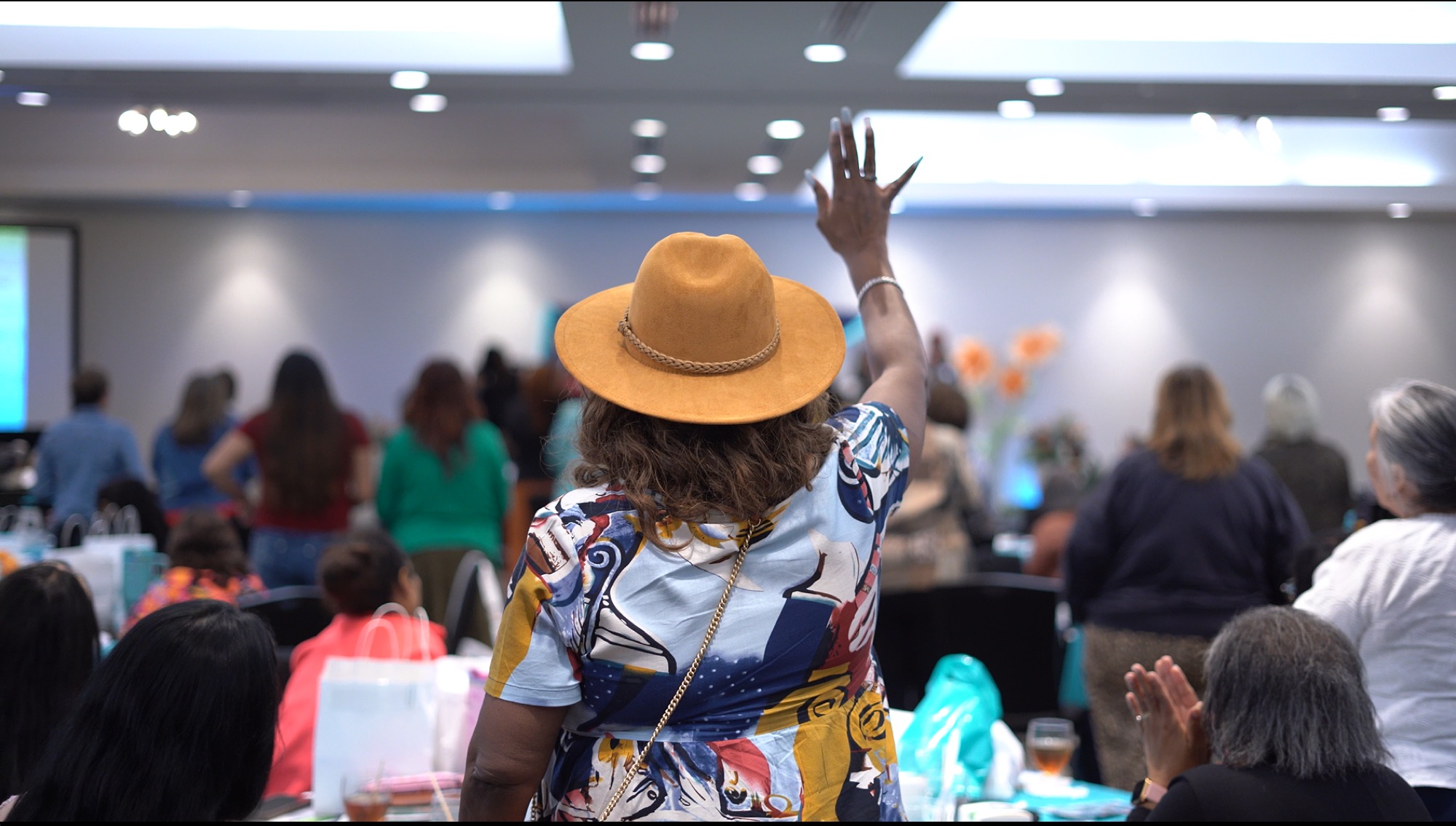 Attendees raising hands in worship at a past Be1 Experience